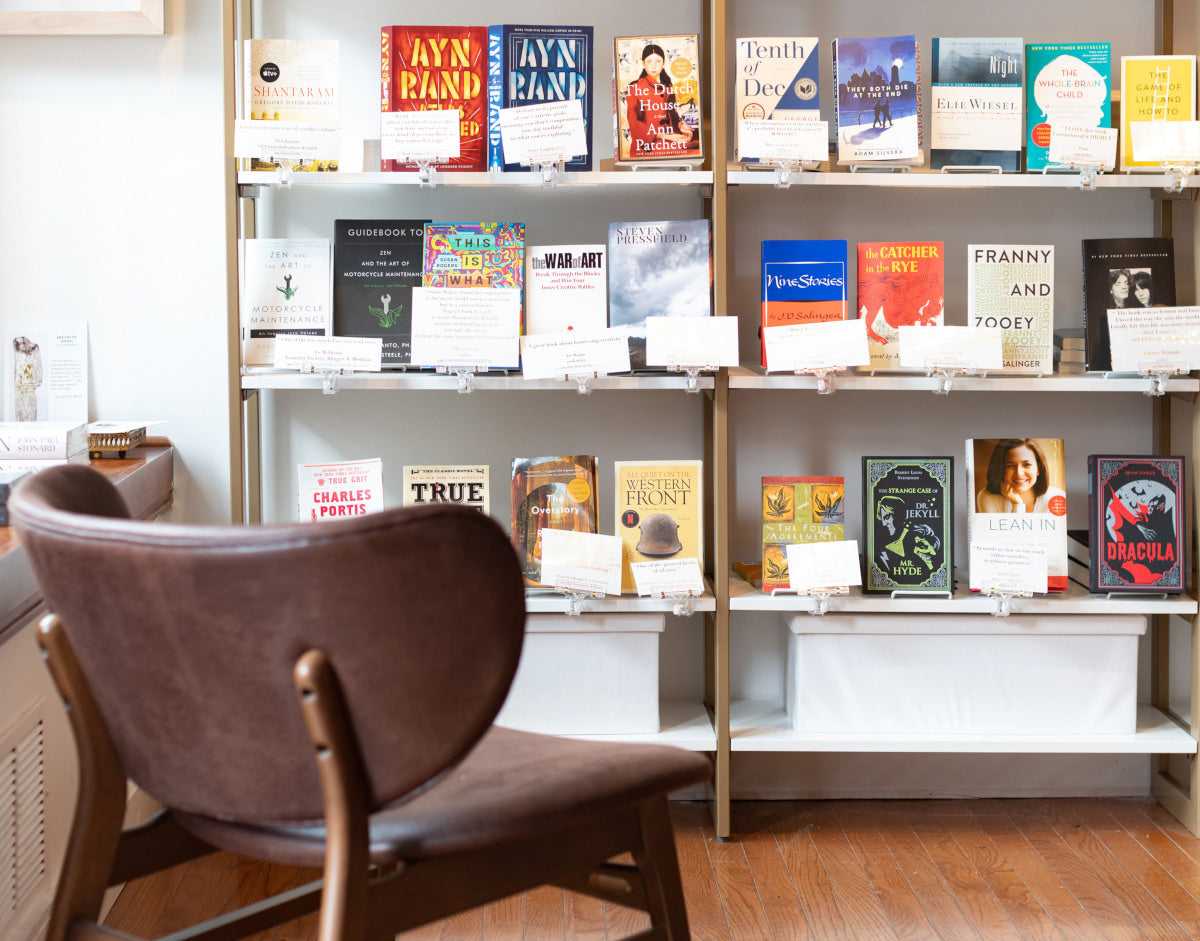 Photo of a comfortable chair and display shelves at Illume Books